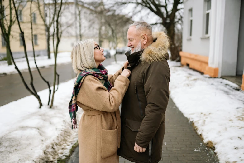 a couple poses for an image during winter on a street