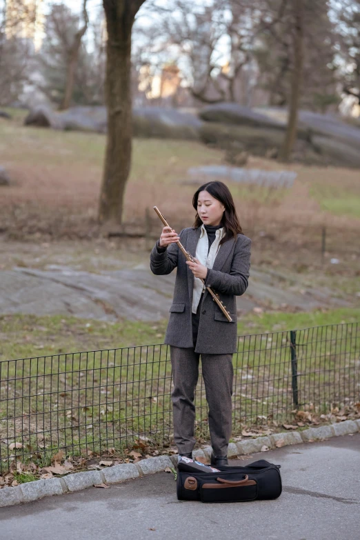 a woman playing an instrument on the side of a road