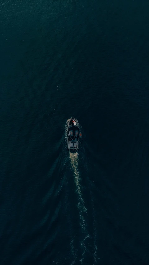 small motorboat traveling through water with a man in the back of it