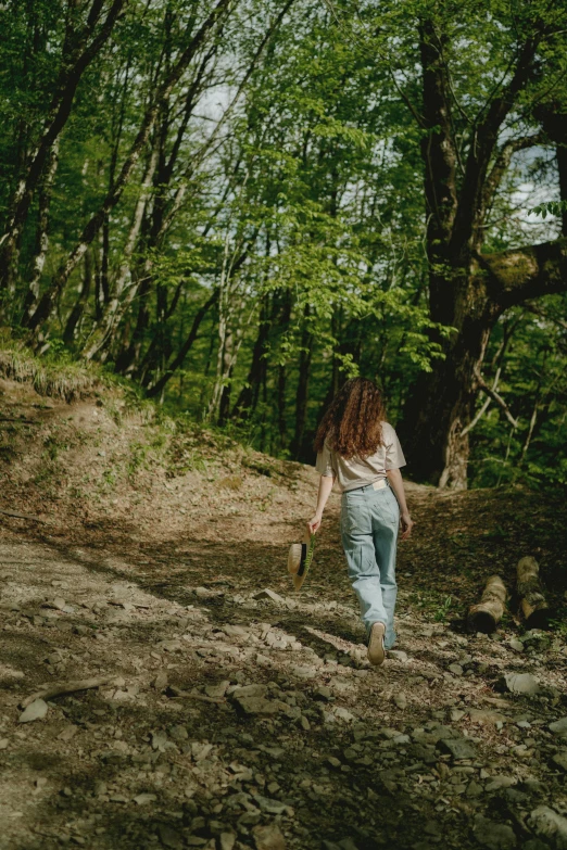 the woman is jogging along a trail in the woods