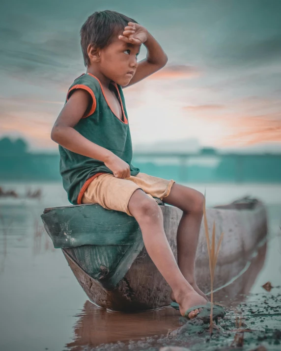 a boy sitting on a boat in the middle of a river