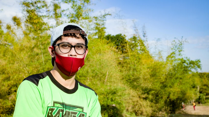 a young man with glasses and a red mask