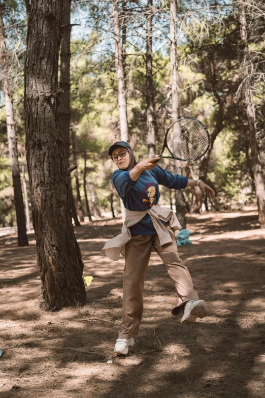 a man holding a tennis racket in the woods