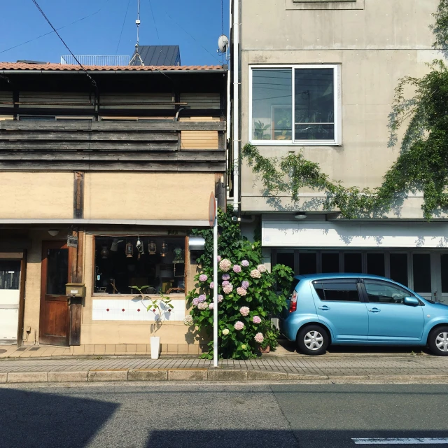 a blue car parked in front of an old building