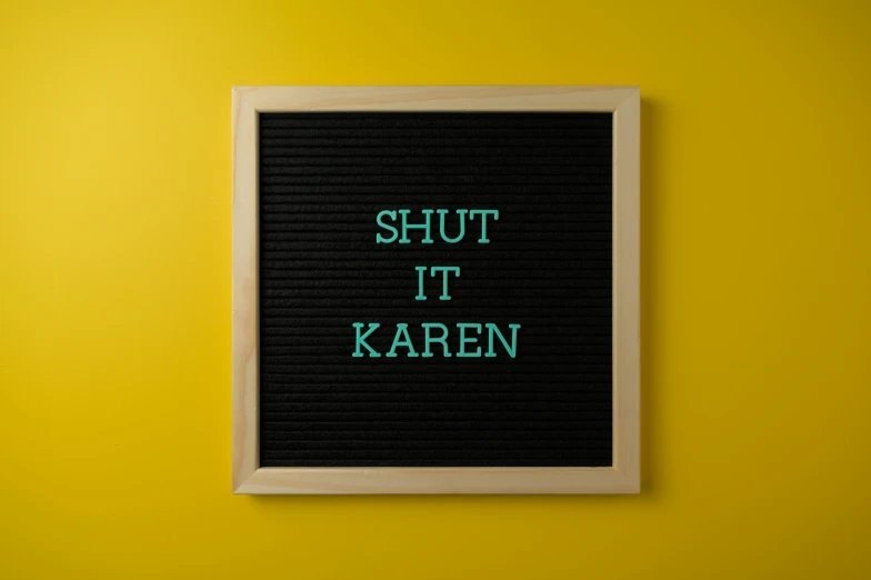 a framed po on a yellow wall with the words shut it karaen written in green