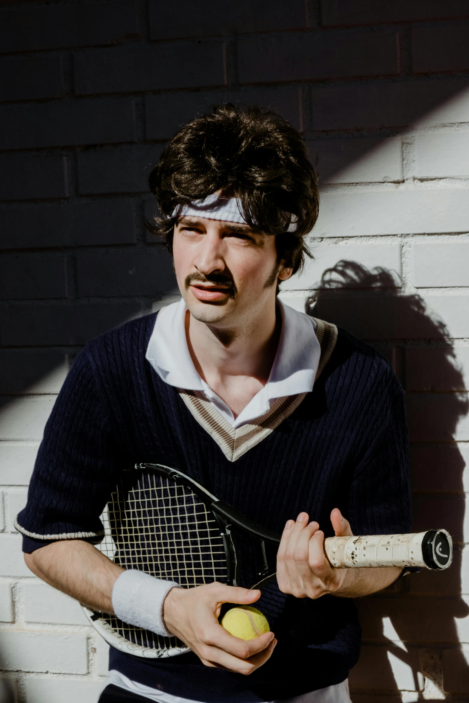 the young man is holding a tennis racket and a ball