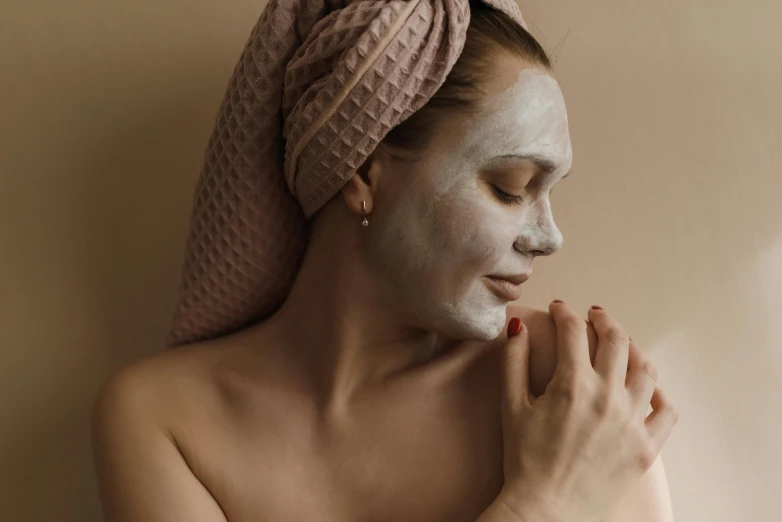 a young woman with clay all over her face and hand