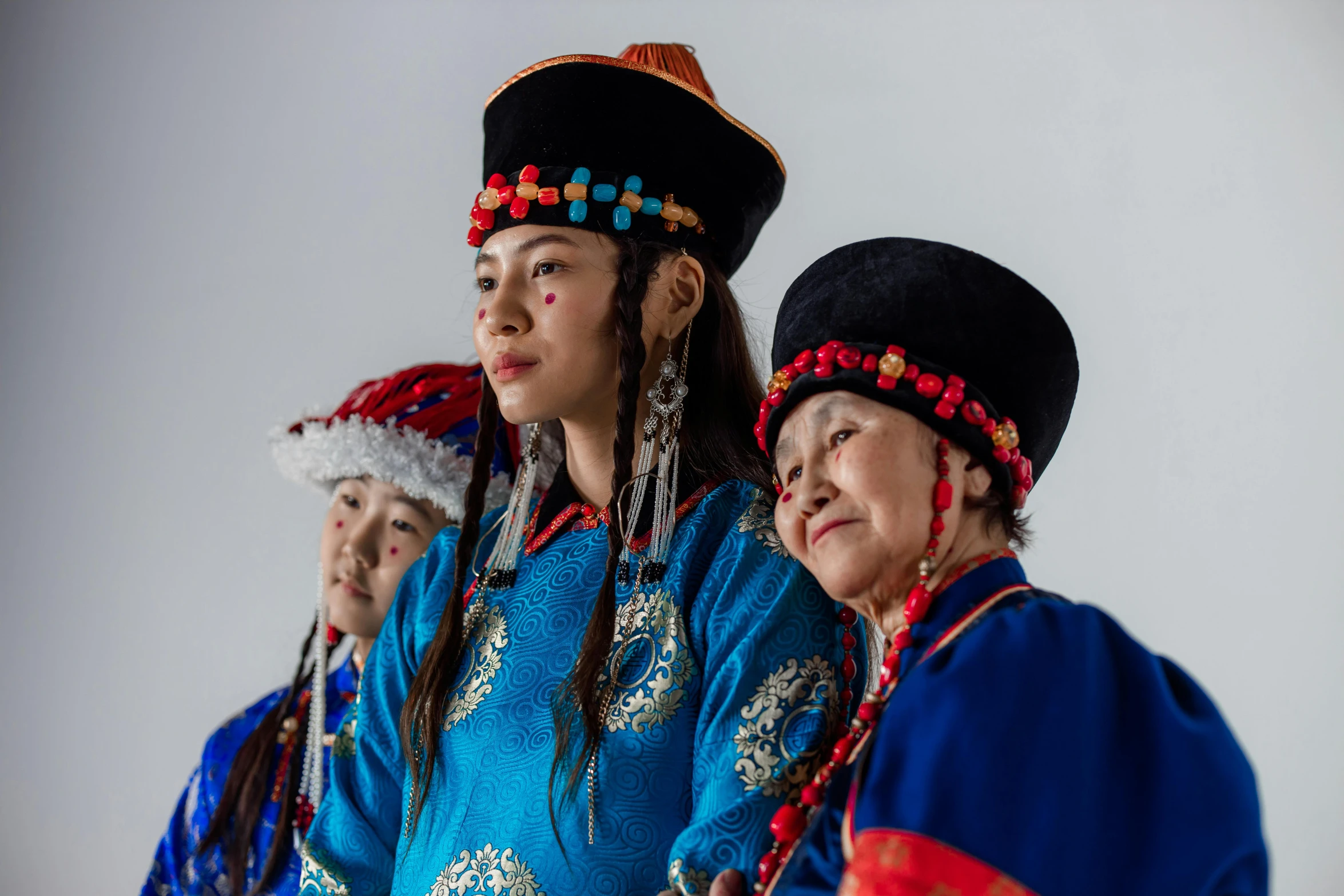 several oriental women wearing different colored ethnic dress