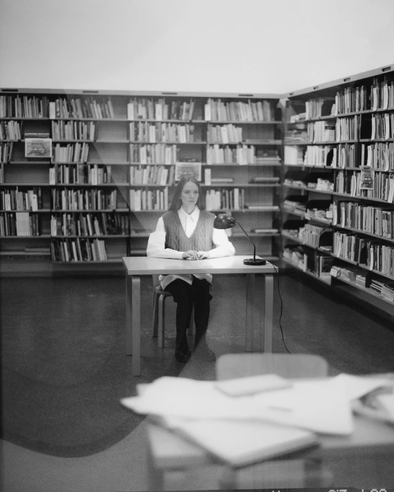 the lady is sitting in the middle of a bookcase