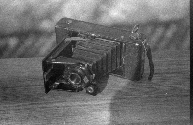 an old camera on a wooden surface