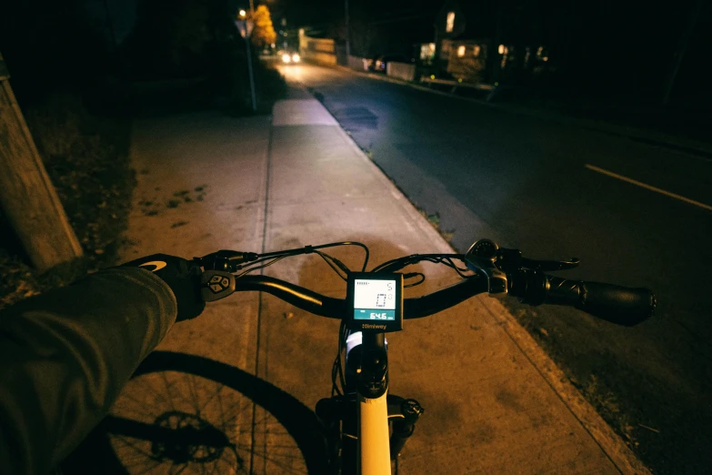 the bicycle rider looks at their smartphone while riding down the street