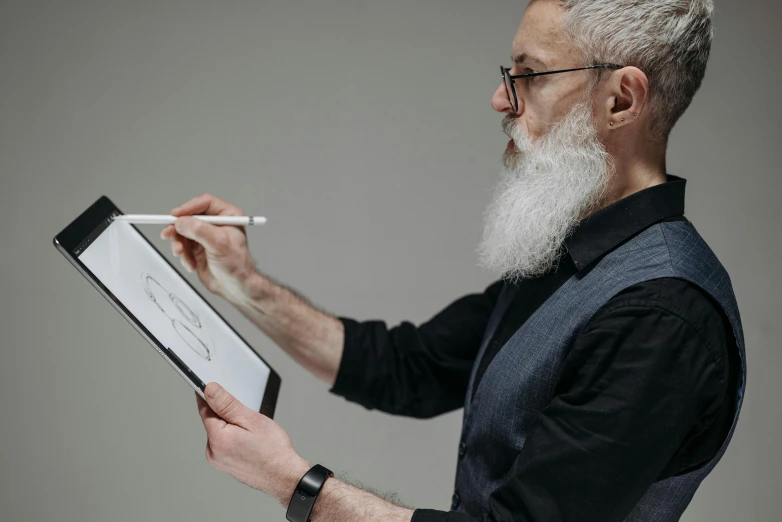 a man with white hair and beard holding a tablet