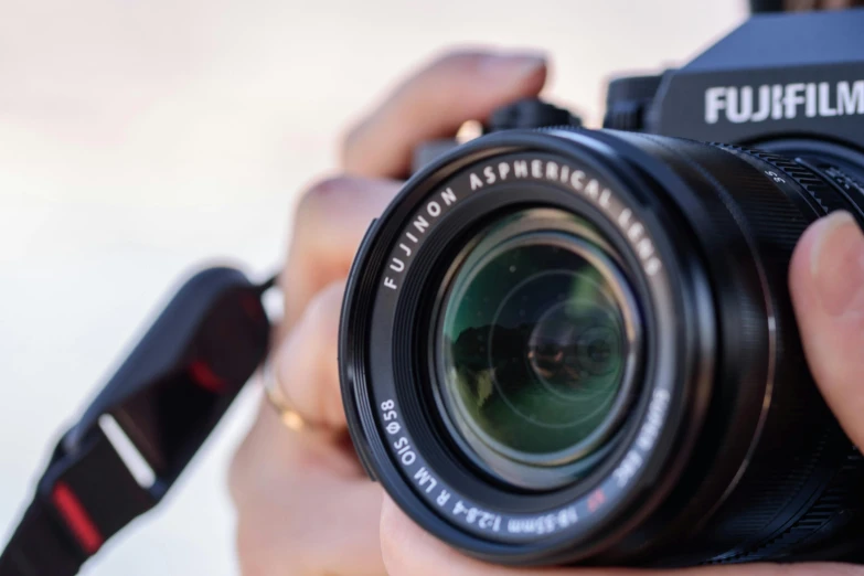 a person holding a camera taking a pograph with a lens