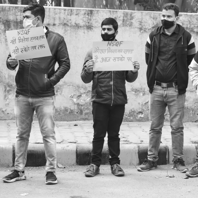 a group of people holding up signs near some stairs