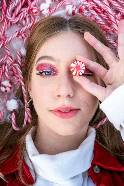 a girl wearing some candy canes looking through her eyes