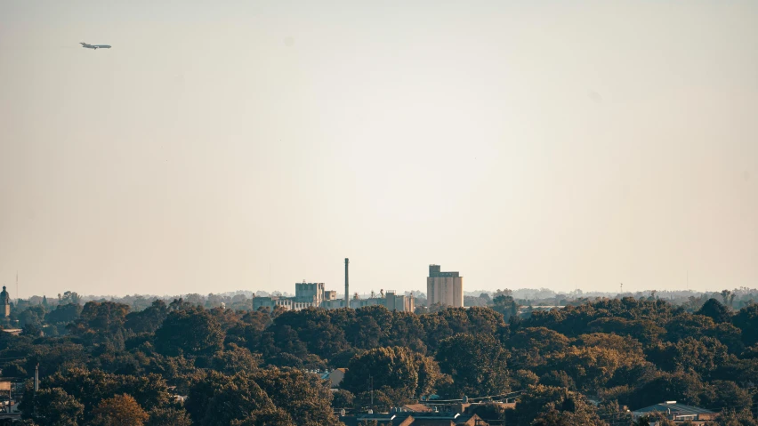 a plane flying in the sky over trees