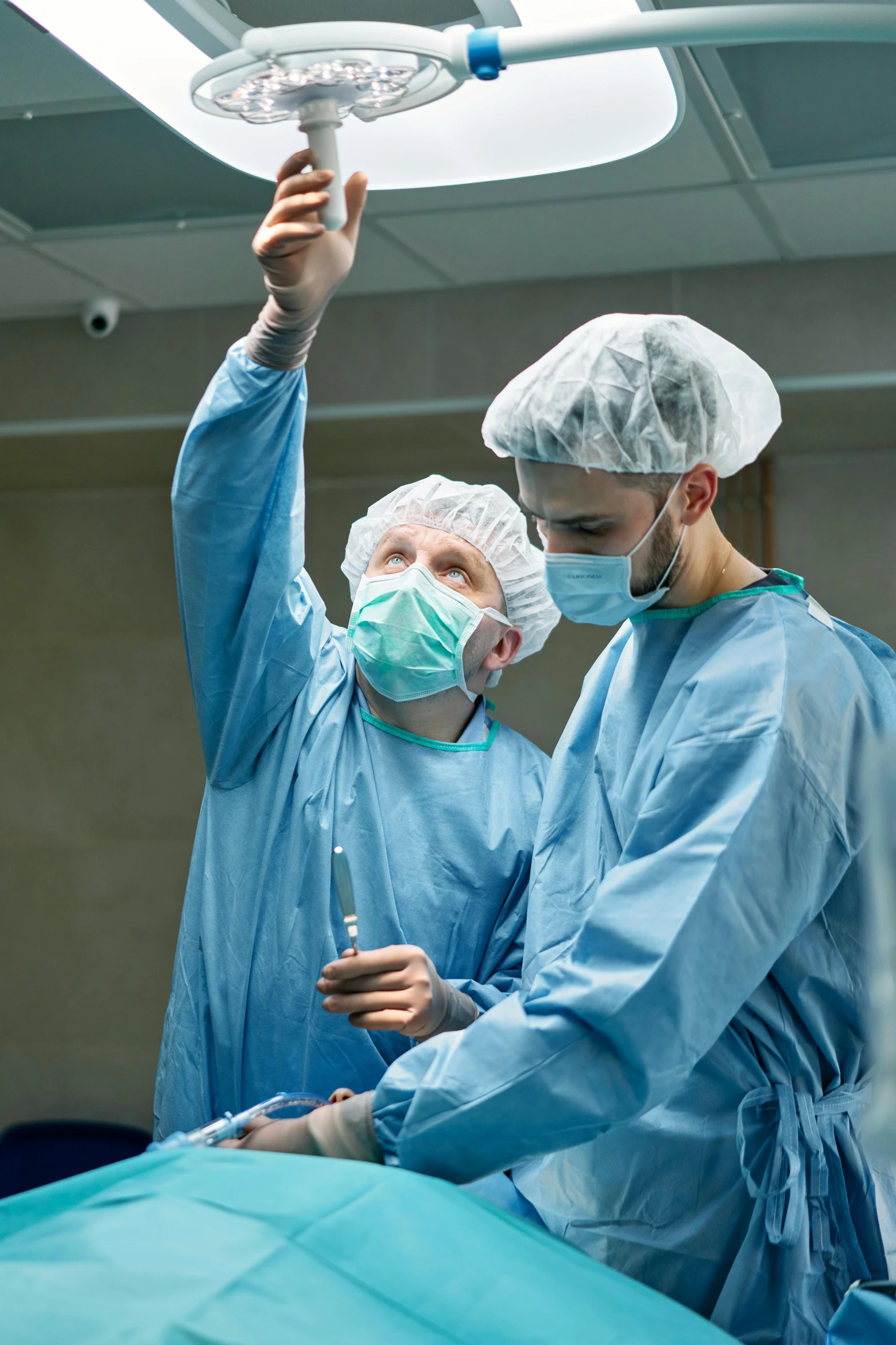 surgeons in sterile gowns perform  on a patient