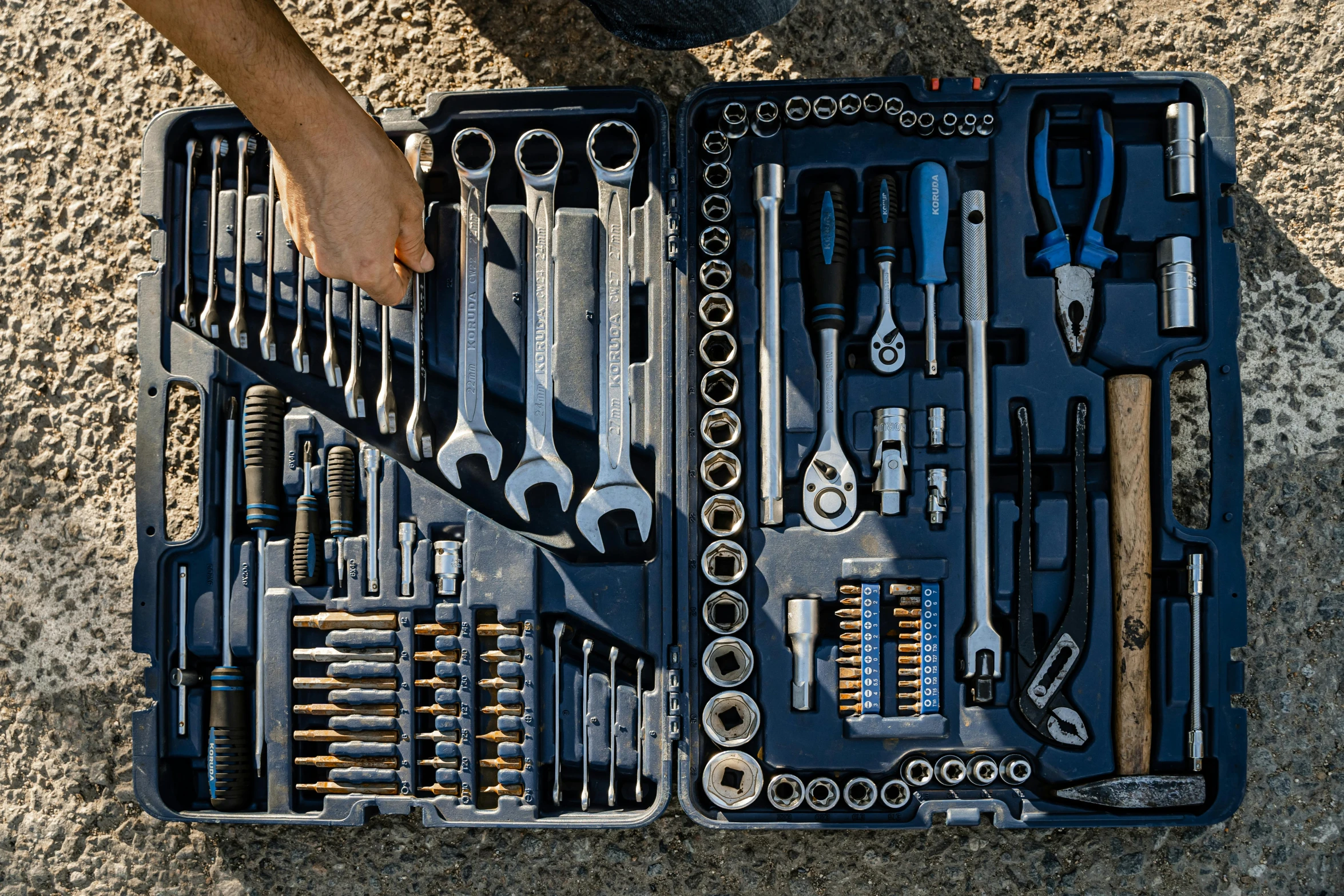 a man looking down at a tool kit