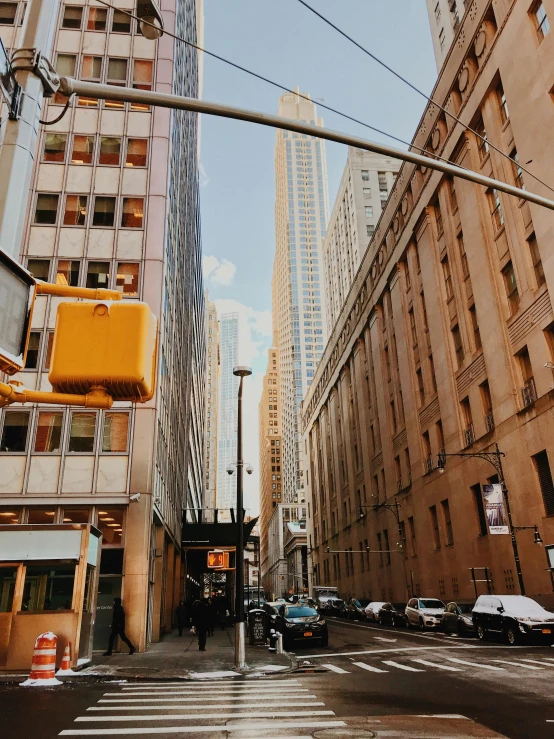 cars driving down an empty street near tall buildings