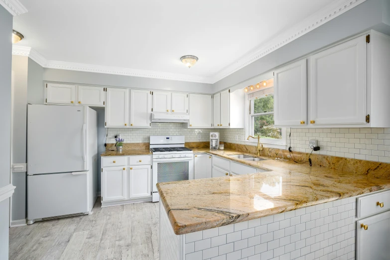 an empty kitchen has white cabinets and granite countertops