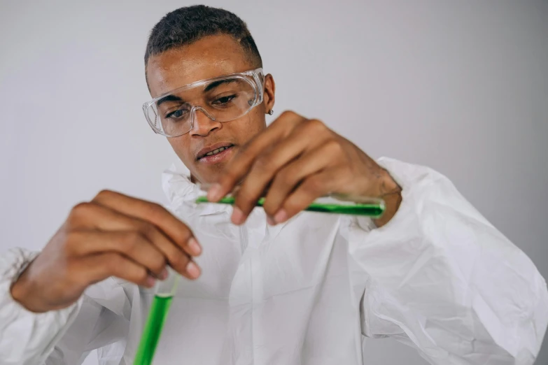 a man in glasses holding a tube with some green material