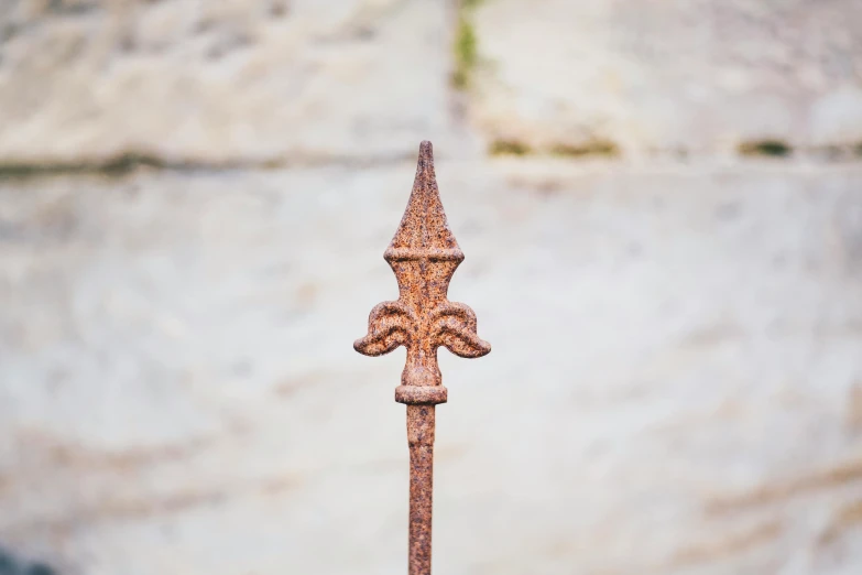 an iron fence post on a concrete background