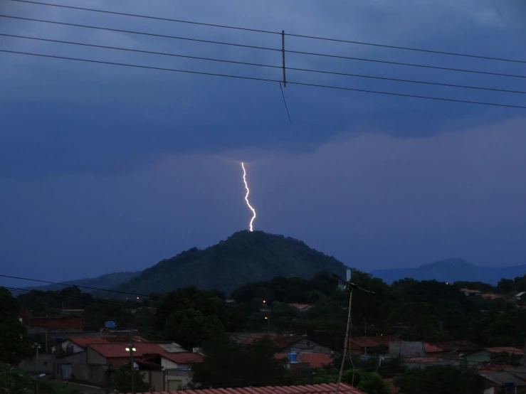 an extremely large bolt hitting the sky in a city