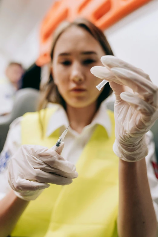 woman with gloves holding a small plastic medical sysor