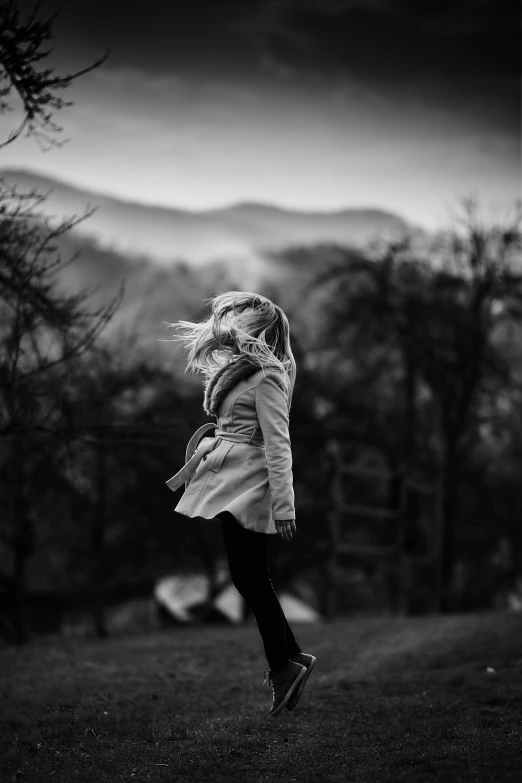 a little girl in black and white playing outside