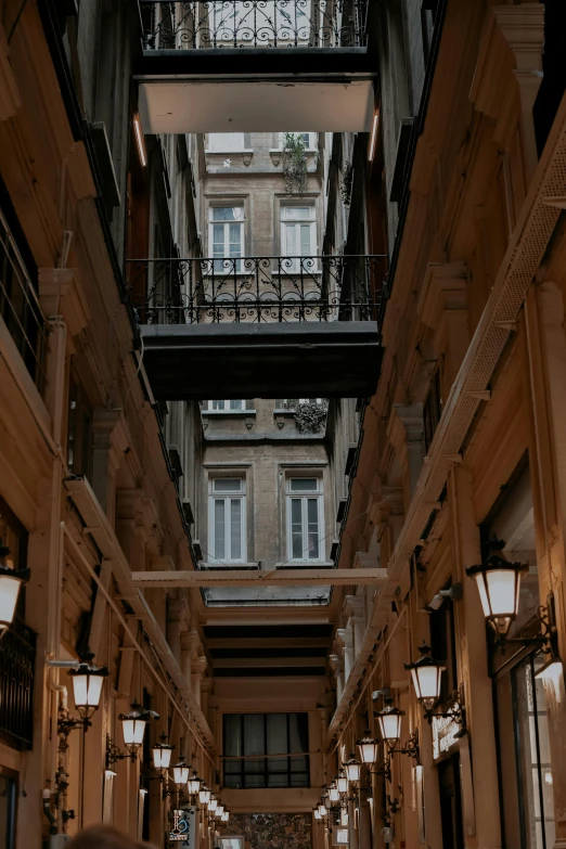 a man walking down the middle of an alley with multiple lights