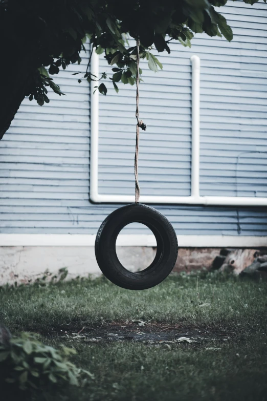 a tire swing hanging from the side of a building