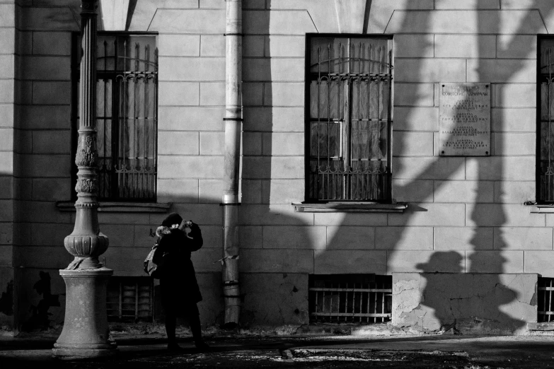 a couple takes a po of a shadow cast on a wall