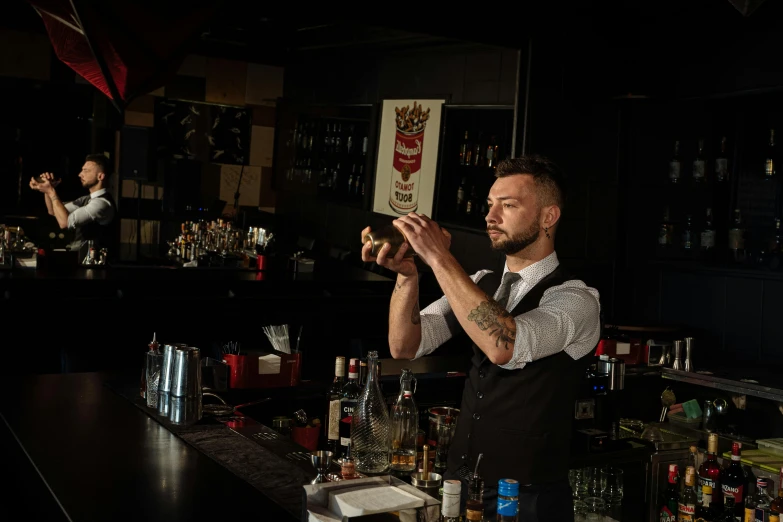 a man is holding up some things at a bar