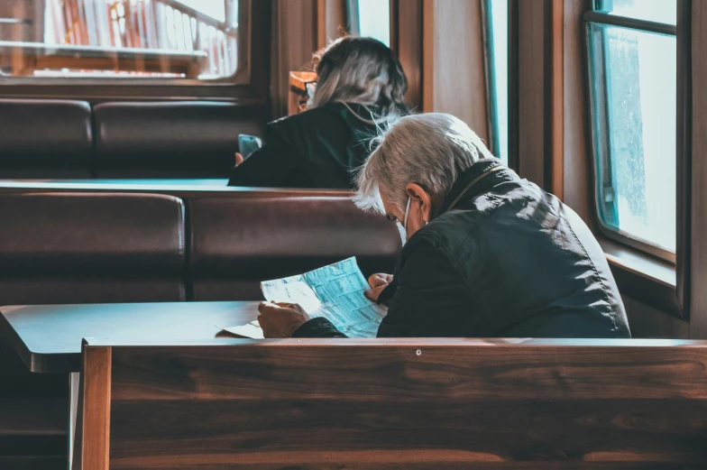 a man sitting in a booth reading a book