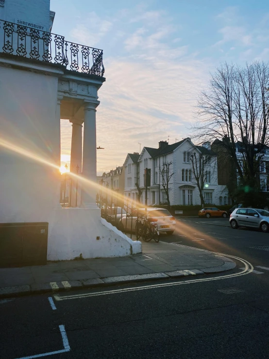 the sun peeks through the clouds above two old buildings