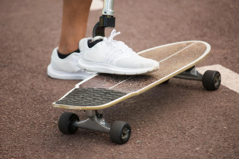 the legs of a man wearing white tennis shoes while standing on a skateboard