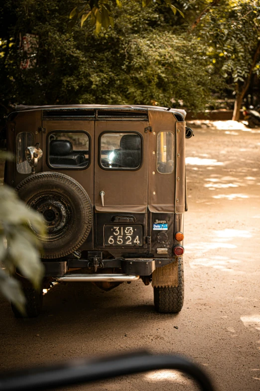 an suv driving down a narrow road in a wooded area