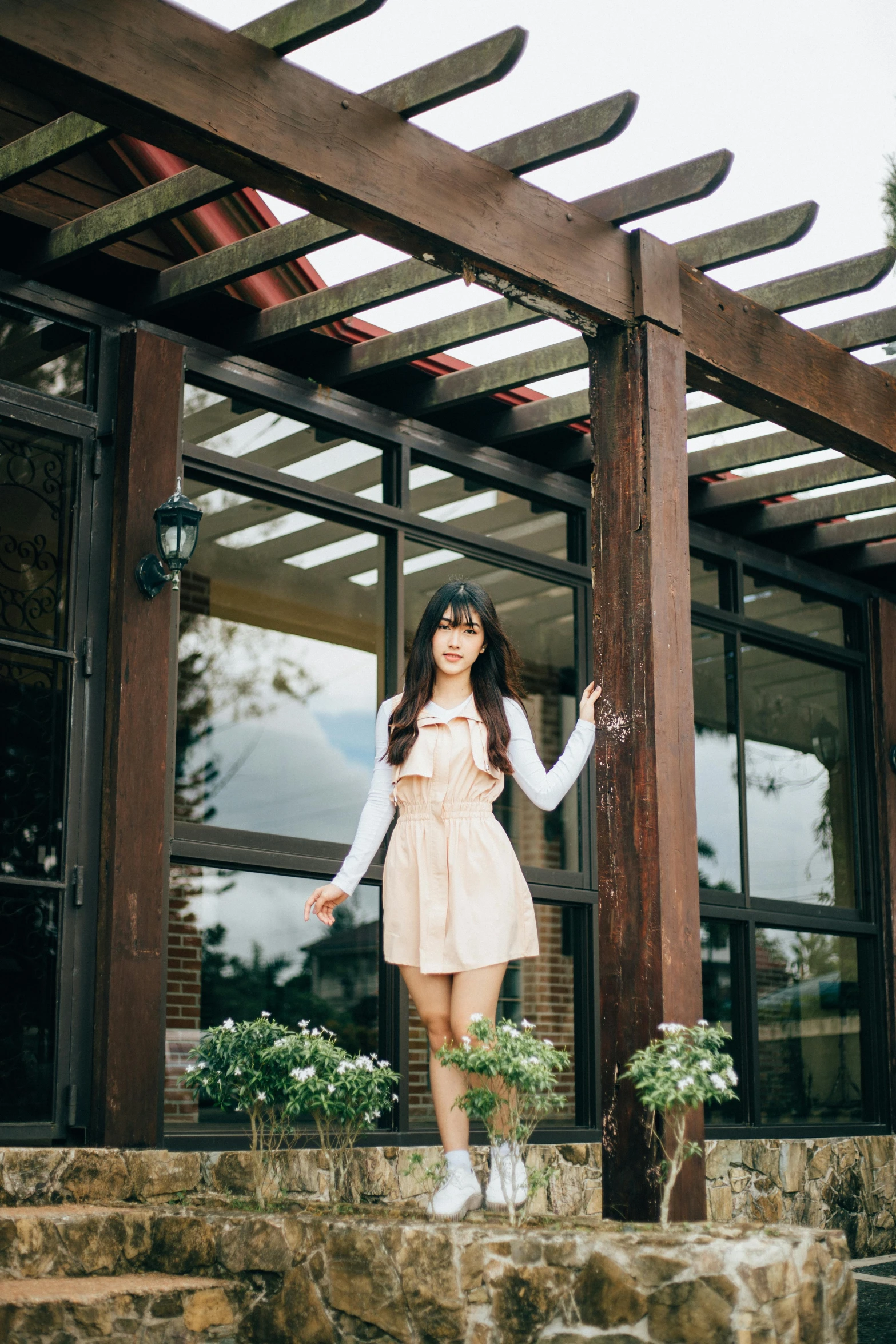 a  poses in front of her house with her hand outstretched