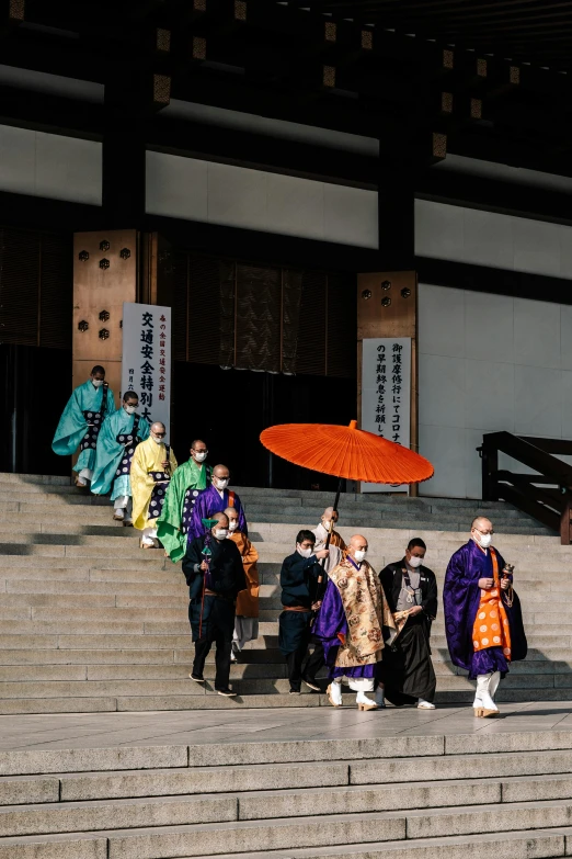 a group of japanese geisha walking up some stairs