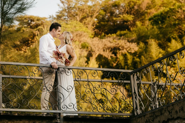 a man and woman are standing on a bridge