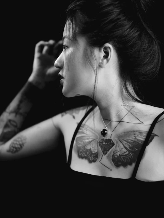 woman with erfly tattoo, looking away from camera