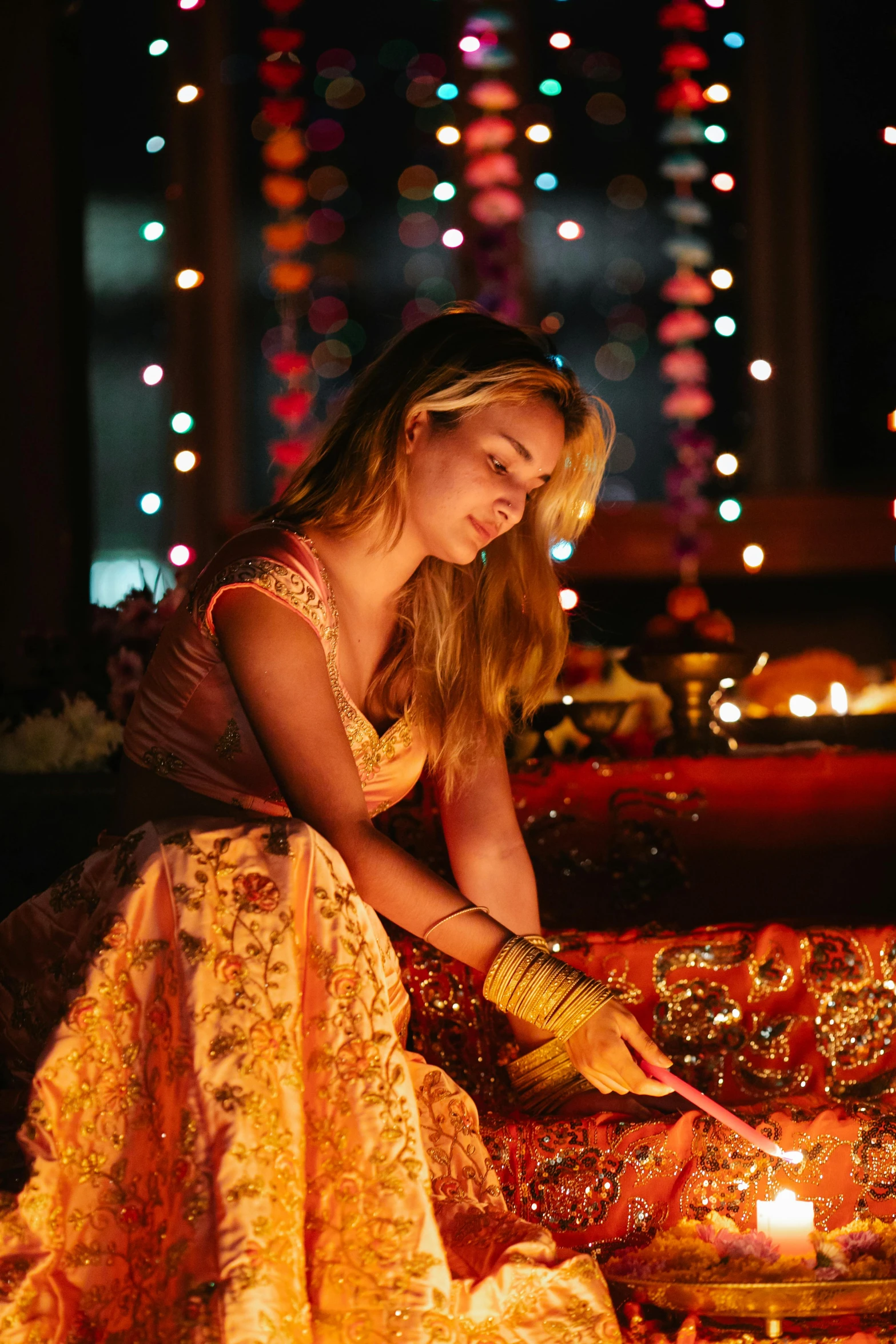 the woman is lighting the diyas using a candle