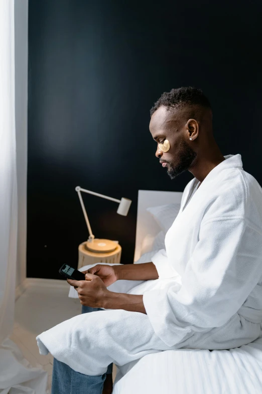 a man with his eyes open is sitting on a bed