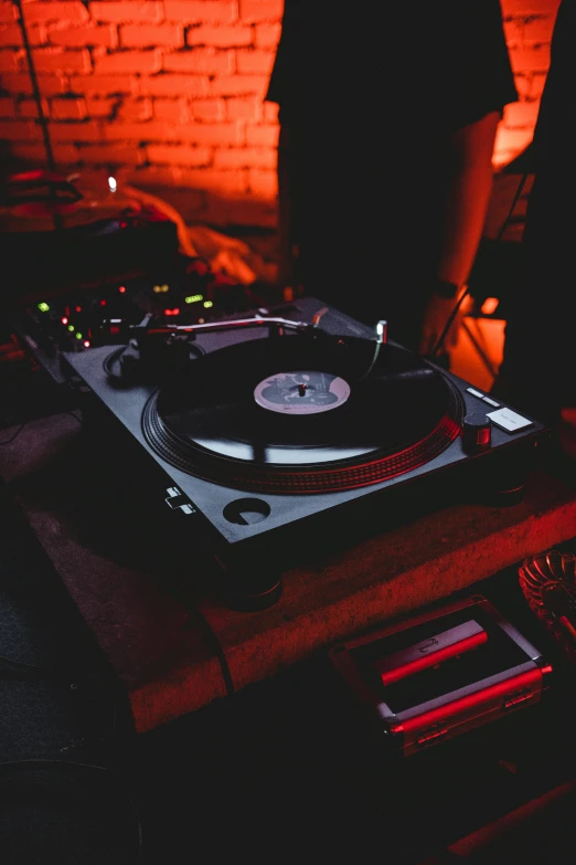 a dj mixing on a turn table in a dark room