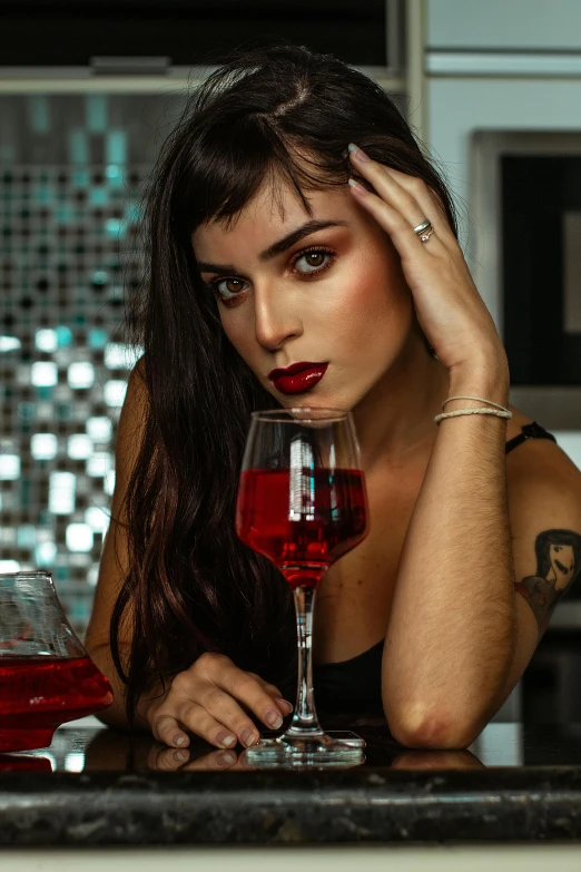 lady with a red liquid in a glass