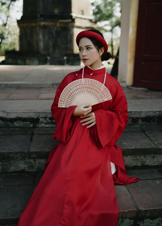 a woman in a red traditional costume sitting on steps