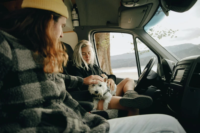 two women sit in the back of an suv