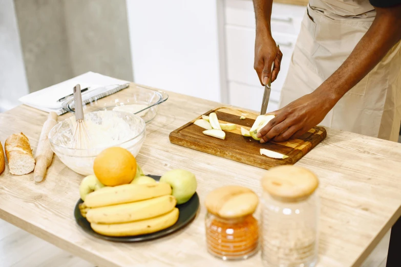 a woman  bread with a knife on a wooden table