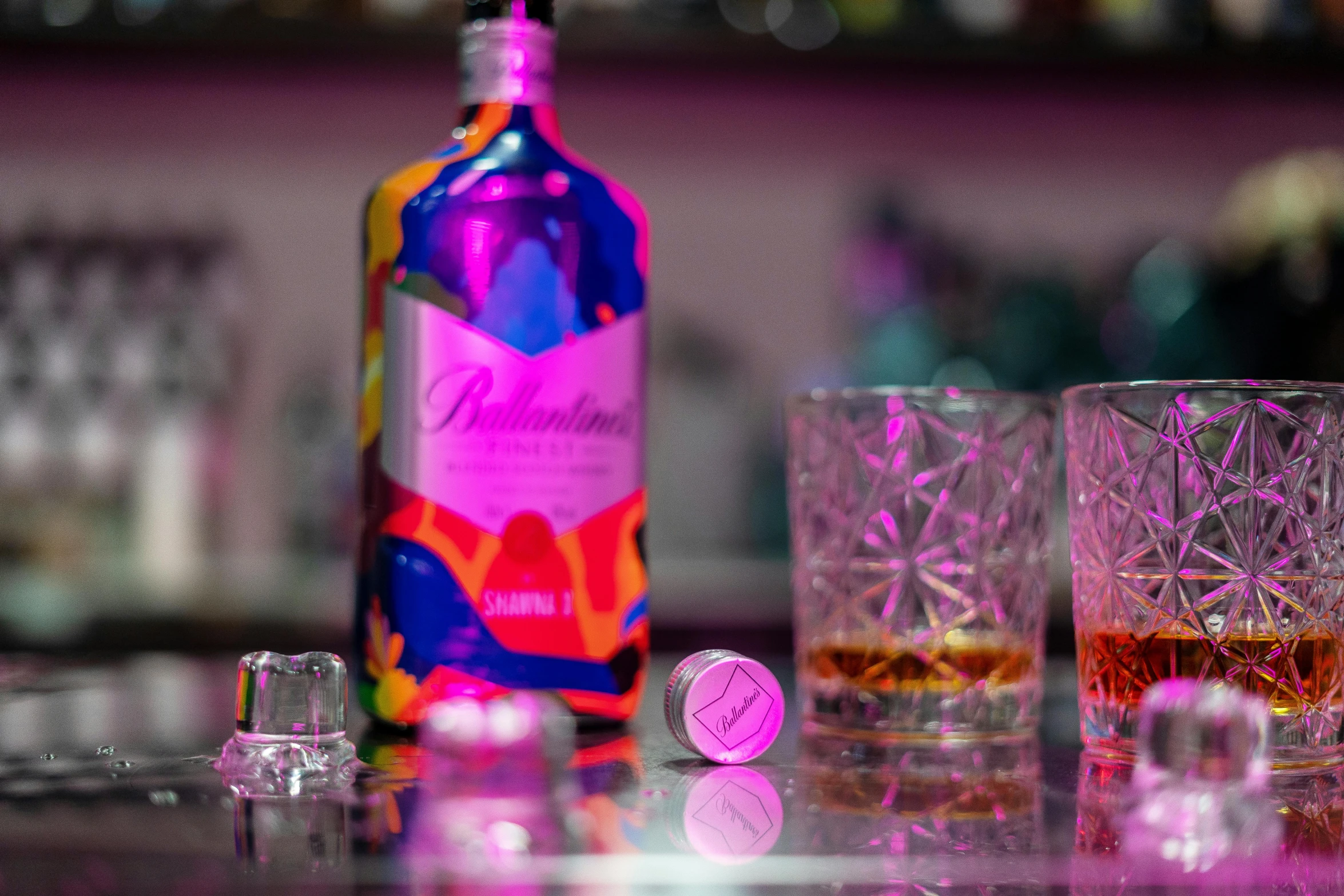 a bottle of liquor sitting next to two glasses