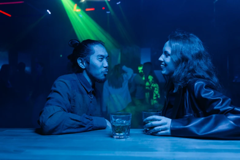 two people sitting at a table talking at a party